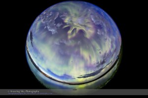 The all-sky aurora of June 22, 2015, during a level 7 to 9 geomagnetic storm, as the display peaked in a substorm with rays converging at the zenith in the darkening twilight of a solstice night. This is one frame from a 568-frame time-lapse, taken with the 8mm Sigma fish-eye lens at f/3.5 and with the Canon 6D, composed for projection in tilt-dome digital planetariums. I was on the south shore of Crawling Valley Lake and Reservoir in southern Alberta.