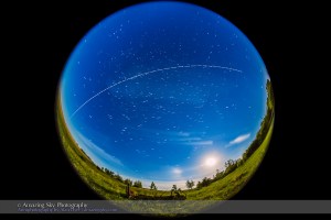 An overhead pass of the International Space Station in a bright moonlit sky on the night of May 31/ June 1, 2015, with the gibbous Moon in the southwest, below. The view is looking south, with the ISS travelling from right (west) to left (east) over several minutes. This was the third pass of a 4-pass night, May 31/June 1, starting at 2:21 am MDT this morning.  This is a composite stack of 66 exposures, each 4 seconds at f/3.5 with the 8mm fish-eye lens and ISO 6400 with the Canon 6D. The gaps are from the 1-second interval between exposures. The length of the trails and gaps reflects the changing apparent speed of the ISS as it approaches, passes closest, then flies away. The stars are trailing around Polaris at top. Unfortunately, I missed catching the start of this pass. I stacked the exposures with the Advanced Stacker Actions from StarCIrcleAcademy.com, using the Lighten mode. The ground comes from a Mean blend of just 8 of the exposures to prevent shadows from blurring but to smooth noise.