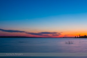Venus and Jupiter on June 28, 2015 approaching a close conjunction two nights later, as seen over the water of Little Fish Lake Provincial Park, Alberta in the evening twilight. Venus is the brighter of the pair. This is an HDR stack of 3 exposures with the Canon 60Da and 16-35mm lens. The long exposure blurs the ripples and waves on the water.