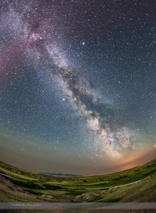 The summer Milky Way over the Milk River Valley and sandstone formations of Writing-on-Stone Provincial park, in southern Alberta. On the horizon are the volcanic Sweetgrass Hills in Montana. The red tint at top is from an aurora active that night and the ground is partly illuminated by green auroral light from the north. The Summer Triangle stars are at top left. Sagittarius is on the horizon sinking into the low clouds at botton right which are illuminated by lights from Sweetgrass, Montana. Clouds and smoke from forest fires to the west cut down the transparency and clarity of the sky this night, especially toward the horizon.  This is a stack of 4 x 3-minute tracked exposures for the sky, and 4 x 5-minute untracked exposures for the ground, all with the 15mm Canon full-frame fish-eye and Canon 6D at ISO 1000, on the iOptron Sky-Tracker unit.