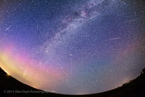 A composite depicting the Perseid meteor shower on the night of Wednesday, August 12, 2015 as shot from southern Alberta, Canada.  The image takes in a wide swath of the north and eastern sky, including the radiant of the shower in Perseus at left of centre, near the Double Cluster visible as a clump of stars. All the Perseids can be traced back to this point. Also in the image: the summer Milky Way and, at left, a dim aurora in green and magenta that was barely visible to the eye but was picked up by the camera. The Andromeda Galaxy is at centre. The Pleiades is just on the horizon. Apart from some haze from forest fire smoke, it was a near perfect night: warm, dry, just a little wind to keep the bugs at bay, and no Moon. A perfect night for a meteor watch.  This is a layered stack of 35 images recording three dozen meteors (most Perseids but also a couple of sporadics not aimed back to the radiant in Perseus, such as the bright one at far left).  The 35 images were selected from 200 shot from 11 pm to 2:30 am that night, with most frames not picking up any meteors. This composite is from the 35 taken over the 3.5 hours that did record a meteor. Each exposure is 1 minute at f/2.8 with the 15mm full-frame fish-eye, on the Canon 5D MkII at ISO 3200 (a couple of the early shots in the sequence were at ISO 1600 for 2 minutes).  The camera was tracking the sky on the Sky-Watcher Star Adventurer tracker, so all images of the stars are aligned and registered out of the camera, with the meteors in their proper position relative to the stars and radiant. I masked out a couple of satellite and aircraft trails that were distracting, and took away from the point of illustrating the radiant of the meteor shower.  The horizon, however, is from one image, taken early in the sequence. Some of the blue in the sky comes from one of the early shots taken in deep twilight but that contained a nice meteor. And I liked the blue it added.  All stacking and processing with Adobe Ca