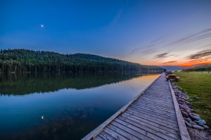 The quarter Moon reflected in the waters of Reesor Lake, Alberta in Cypress Hills Interprovincial Park. Taken on July 5, 2014. This is with the 14mm Rokinon lens and Canon 6D at ISO800. This is a high dynamic range stack of6 exposures from 1/15 to 0.6 seconds taken just before using the camera to take a motion control time-lapse. The Moon was in conjunction with Mars (right of Moon) and Spica (left of Moon) but in the bright twilight they are not showing up here.