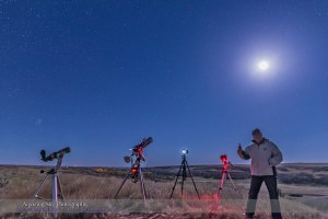 Me celebrating a successful total eclipse of the Moon during the final partial phases, observed and shot from Writing-on-Stone Provincial Park, Alberta, on September 27, 2015. I shot with 3 cameras, with a 4th to record the scene. Two of the cameras at centre are still shooting time-lapses of final partial phases. The camera at right was used to take long tracked exposures of the Milky Way during totality. The telescope at left was used just to look!
