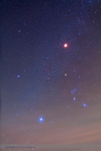 Total eclipse of the Moon, December 20/21, 2010, taken from home with Canon 5D MKII and 24mm lens at f2.8 for stack of 4 x 2 minutes at ISO 800. Taken during totality. The eclipsed Moon is the red object above Orion, and the stars appear bloated due to high haze and fog rolling in, visible at the bottom.