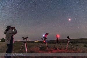 Me, in a selfie, observing a total eclipse of the Moon with binoculars on September 27, 2015, from Writing-on-Stone Provincial Park, Alberta. I had three cameras set up to shoot the eclipse and a fourth to shoot the scene like this. The night was perfect for the eclipse. The Moon is in totality here, with the stars and Moon trailed slightly from the long exposure.