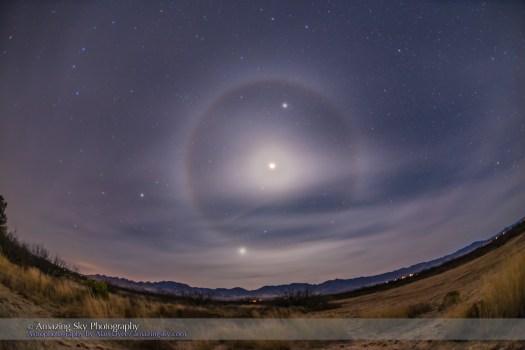A classic 22° ice crystal halo around the waning crescent Moon, here overexposed, with the Moon between Jupiter and Mars in the morning sky on December 5, 2015. Seeing a halo around a crescent Moon is somewhat rare as they usually require the brighter light of the Full Moon. Venus is the brightest object at bottom closest to the horizon. The three planets, along with the stars Spica (above Venus) and Regulus (at top of frame) define the line of the ecliptic here in the dawn late autumn / early winter sky. I captured this scene from southeast Arizona near the Arizona Sky Village at Portal. This is a stack of 4 exposures from long to short (8s to 1/2s) to encompass the great range in brightness and not overexpose the crescent Moon too much. Images were layered in Photoshop and masked with luminosity masks. Automatic HDR techniques did not work well as the shortest image was too dark for ACR to find content to register in Merge ot HDR, and in Photoshop the HDR Pro module left visible edge artifacts. The camera was on the iOptron Sky Tracker to follow the sky and register the sky for all the exposures, thus the slightly blurred ground. Taken with the Canon 6D and 15mm full-frame fish-eye lens.
